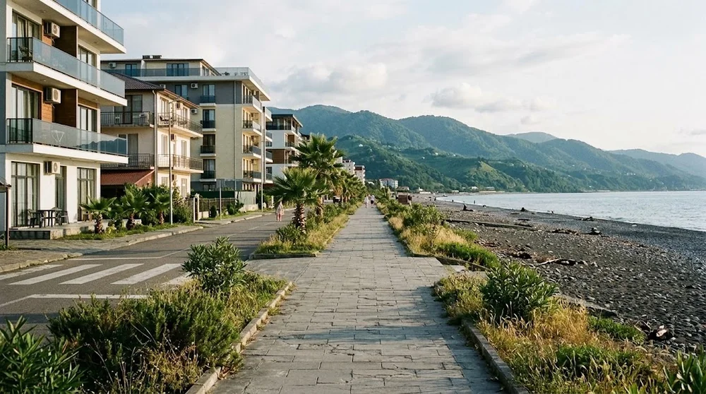 Chemin piéton et traversée de route vers une plage de galets à Gonio